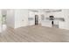Spacious living area featuring an open floor plan, sleek flooring, and a modern white kitchen with stainless steel appliances at 634 Burch Ave, Winter Garden, FL 34787