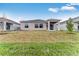 Home's backyard with green grass, a covered patio and a view of neighboring houses at 345 River Front Way, Edgewater, FL 32141