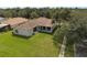 Aerial view of the property showcasing the lush green lawn and covered patio with tile roof at 11045 Belmere Isles Ct, Windermere, FL 34786