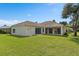 Expansive backyard with lush green grass and a covered patio perfect for outdoor enjoyment at 11045 Belmere Isles Ct, Windermere, FL 34786