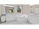 Bright bathroom featuring double sinks, white cabinets, and a soaking tub with natural light at 11045 Belmere Isles Ct, Windermere, FL 34786