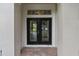 Elegant double front doors with decorative glass panels and brick walkway at 11045 Belmere Isles Ct, Windermere, FL 34786