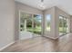 Living room with light wood-look flooring and sliding glass doors that open to an outdoor patio at 11045 Belmere Isles Ct, Windermere, FL 34786