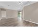 Spacious living room showcases a modern chandelier and light wood-look flooring at 11045 Belmere Isles Ct, Windermere, FL 34786