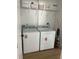Bright laundry room with newer washer and dryer and ample shelving for storage of laundry supplies at 13356 Sw 64Th Street Rd, Ocala, FL 34482