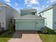 Home exterior featuring a two-car garage with brick paved driveway and manicured lawn at 524 Orient Ave, Debary, FL 32713