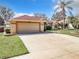 House exterior showcasing a two-car garage and well-maintained yard at 10324 Pleasant View Dr, Leesburg, FL 34788