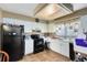 Galley-style kitchen with white cabinets and black appliances at 4621 N Pine Hills Rd # 113, Orlando, FL 32808