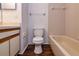 Bathroom featuring a tiled bathtub, toilet, and vanity with cabinets at 10557 Glassborough Dr, Orlando, FL 32825