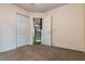 Bedroom featuring neutral carpet, light walls, double closet doors, and a view to the spiral staircase at 10557 Glassborough Dr, Orlando, FL 32825