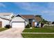 Charming single-Gathering home featuring a two-car garage, well-maintained lawn, and inviting curb appeal at 10557 Glassborough Dr, Orlando, FL 32825