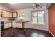 Eat-in kitchen featuring white cabinets, laminate countertops, essential appliances and views of the backyard at 10557 Glassborough Dr, Orlando, FL 32825