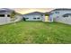 Backyard with a green lawn, modern fence, and covered patio, creating a peaceful outdoor space at 1393 Asher Mason Ave, Kissimmee, FL 34744