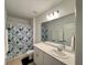Bright bathroom featuring a shower-tub combo and a large vanity mirror at 1393 Asher Mason Ave, Kissimmee, FL 34744