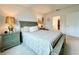 A cozy bedroom is shown with matching nightstands, lamps, carpeted floor and ensuite access at 1393 Asher Mason Ave, Kissimmee, FL 34744