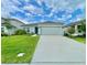 Charming single-story home with a well-manicured lawn and a two-car garage at 1393 Asher Mason Ave, Kissimmee, FL 34744