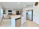 A modern kitchen features an island with stainless steel appliances and flows into the living room at 1393 Asher Mason Ave, Kissimmee, FL 34744