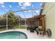 Relaxing screened-in pool area with lounge chairs, conversational seating, and shaded pergola at 246 Kimberly Point Dr, Davenport, FL 33837