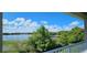 Stunning lake view from the balcony, surrounded by lush greenery and a bright, partly cloudy sky at 593 Lake Wildmere Cv, Longwood, FL 32750