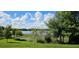 Scenic lake view surrounded by mature trees and vibrant greenery under a partly cloudy sky at 593 Lake Wildmere Cv, Longwood, FL 32750