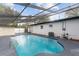 The screened-in pool features a blue tile border and a gray concrete deck at 920 S Solandra Dr, Orlando, FL 32807
