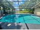 Screened pool with clear blue water with an expansive outdoor view and covered seating area at 920 S Solandra Dr, Orlando, FL 32807