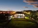 Aerial view of the property at twilight with screened-in patio and pool at 13016 Shady Retreat Loop, Clermont, FL 34711