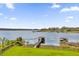 Lakeside backyard features green grass, a black fence, and dock access to the water at 13016 Shady Retreat Loop, Clermont, FL 34711