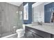 Modern bathroom featuring a glass-enclosed shower, sleek vanity, and blue accent wall at 13016 Shady Retreat Loop, Clermont, FL 34711