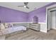 Lavender-painted bedroom with a double bed and dresser at 13016 Shady Retreat Loop, Clermont, FL 34711