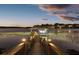 Picturesque covered boat dock with a lift, set against a serene lake and illuminated by warm lighting at twilight at 13016 Shady Retreat Loop, Clermont, FL 34711