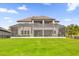 Backyard view of the home featuring a screened lanai, perfect for outdoor entertaining, seamlessly blending indoor-outdoor living at 13016 Shady Retreat Loop, Clermont, FL 34711