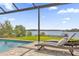 Resort-style pool area with lounge chairs overlooking the serene lake, perfect for relaxation at 13016 Shady Retreat Loop, Clermont, FL 34711