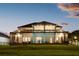 Elegant back of home featuring a covered patio, and a spacious lawn at dusk at 13016 Shady Retreat Loop, Clermont, FL 34711