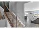 View of carpeted staircase with decorative iron railing, adjacent to open living area and view of lake at 13016 Shady Retreat Loop, Clermont, FL 34711