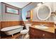 Bathroom with classic fixtures, vintage-style clawfoot tub, and decorative wallpaper at 2459 Adelia Blvd, Deltona, FL 32725