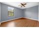 This bedroom has wood laminate flooring and a window that lets in natural light at 2717 Eagle Cliff Dr, Kissimmee, FL 34746