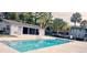 A community pool is surrounded by buildings and mature trees at 4743 S Texas Ave # 4743B, Orlando, FL 32839