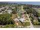 Aerial view of a neighborhood with well-kept homes, lush landscaping, and a glimpse of a lake at 12009 Eagle Point Ct, Leesburg, FL 34788