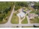 Aerial view of a well-maintained home with a spacious yard, pool, and landscaping in a quiet neighborhood at 12009 Eagle Point Ct, Leesburg, FL 34788