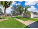 Large backyard with a playground, shed, and mature palm trees at 12009 Eagle Point Ct, Leesburg, FL 34788