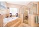 Bathroom with separate shower, soaking tub, and large glass block window at 12009 Eagle Point Ct, Leesburg, FL 34788