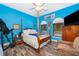 This bedroom features blue walls, wood-look floors, and natural light from the windows at 12009 Eagle Point Ct, Leesburg, FL 34788