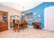 Dining room boasts blue accent wall, wood table set, and cabinet for display at 12009 Eagle Point Ct, Leesburg, FL 34788