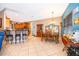 Open dining area with tile flooring, wooden table, and a breakfast bar with seating at 12009 Eagle Point Ct, Leesburg, FL 34788
