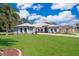 Well-maintained, single-story home with arched windows and a spacious front lawn on a sunny day at 12009 Eagle Point Ct, Leesburg, FL 34788