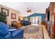 Spacious living room with vaulted ceilings, tile floors, blue sofas, and decorative rug at 12009 Eagle Point Ct, Leesburg, FL 34788