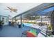 Screened-in pool area with ample lounge seating, outdoor dining, and ceiling fans at 12009 Eagle Point Ct, Leesburg, FL 34788
