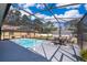 Screened pool area includes a dining table and chairs, pool, and spa at 12009 Eagle Point Ct, Leesburg, FL 34788