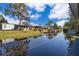 A waterfront view of a house with a private dock and boat lift at 12009 Eagle Point Ct, Leesburg, FL 34788
